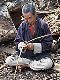 In the Himalayan kingdom of Bhutan, a man prepares fiber for weaving.